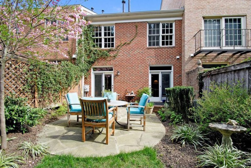 carved stone bird bath with turtle bird bath accent and flagstone irregular cut patio pavers with brick siding and lattice wooden fence also working as trellis