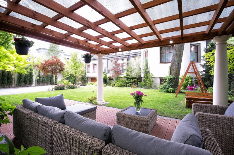 doric pergola columns with hardwood rafters and purlins and sun protecting corrugated polycarbonate roof sheet with wood deck “carpet” on deck and mounted stainless steel outdoor lights