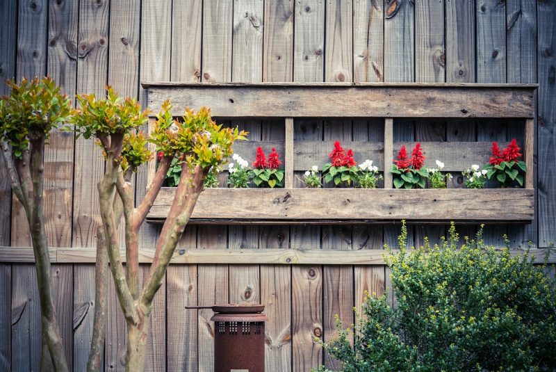 hardwood solid board privacy fence and DIY 3-panel wood pallet container garden with vintage patio warmer and bird feeder