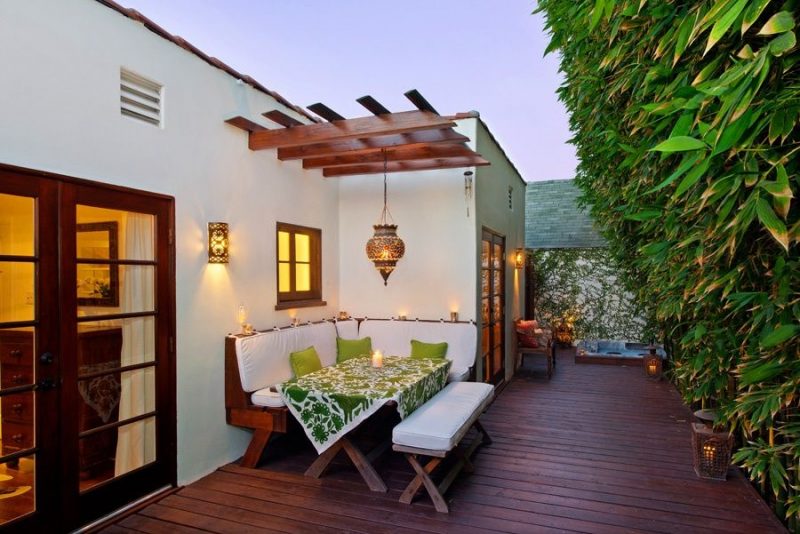 dinner nook with moroccan pendant light and mood lanterns on deck with in-ground jacuzzi and pergola