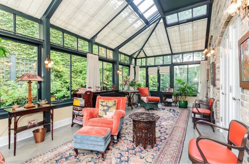 skylight roller blinds with forest green aluminum sunroom beams and columns and rattan chaise lounge with custom carved wood side table and rectangular area rug