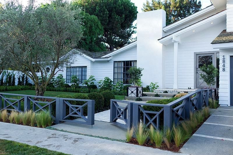southern cross fence panels with grass mulched parterre and topiaries flanking pathway and iron planter matching fence design with square tiles and concrete top step