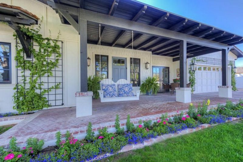 attached covered pergola roof and timber columns with stucco base and aluminum attached wall and garage door trellis and parterre with brick edging and brick porch pavers with herringbone pattern