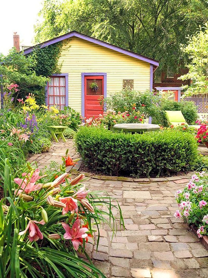 colorful home exterior paint calling back various hues from the garden and round topiary surrounding bird bath centerpiece with Arizona flagstone walkway and lattice fence with bold apple green lounge chair and side table